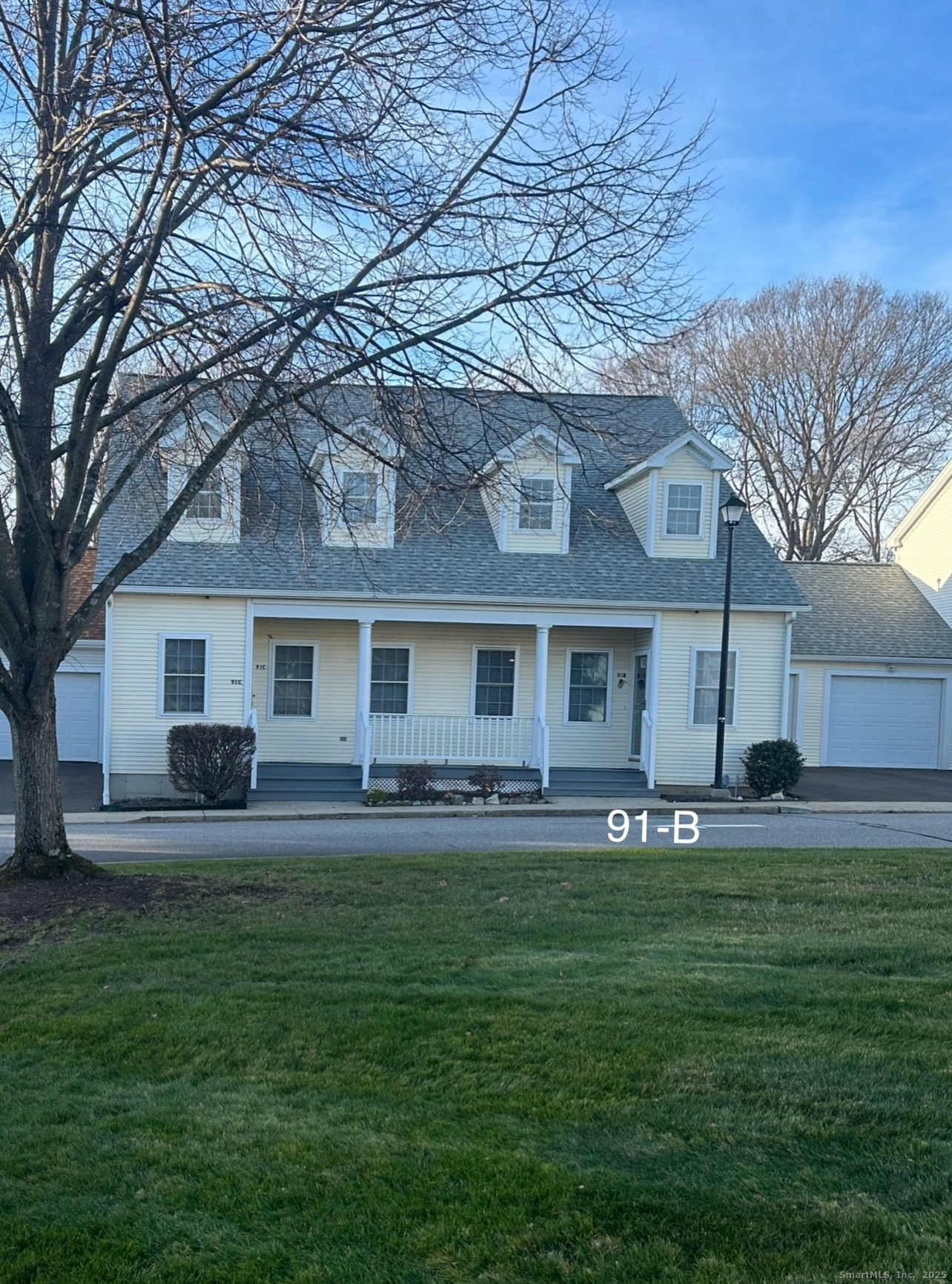 91 Forest Road, Unit B Milford, CT 06461 - Photo 2 of 28 a front view of a house with a garden and trees