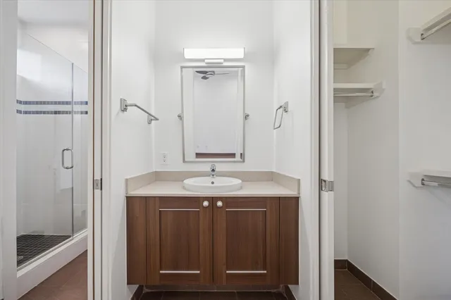 a bathroom with a granite countertop sink a mirror and a shower