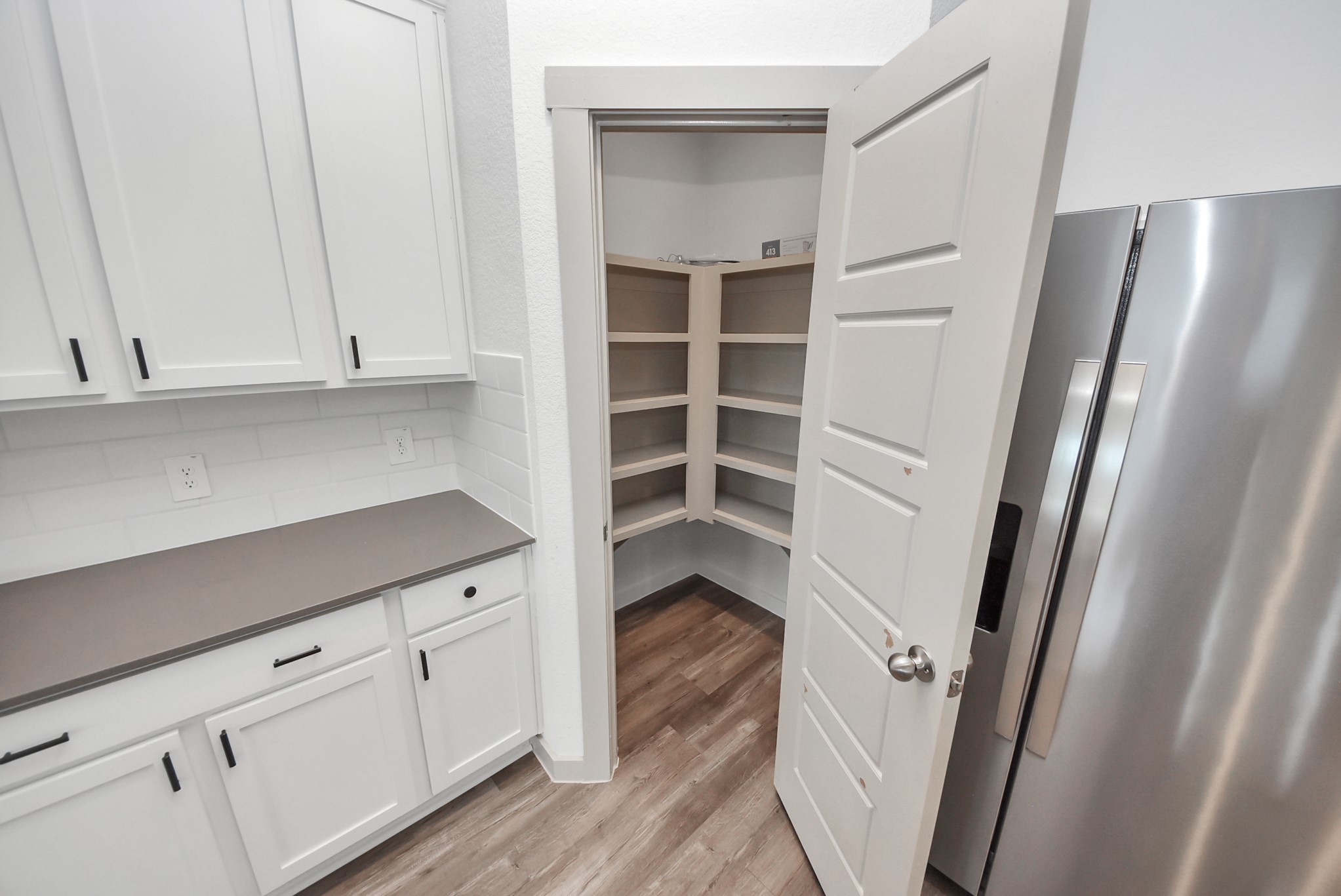 7911 Wrangler Shack Lane Rosharon, TX 77583 - Photo 35 of 40 Bright and functional kitchen pantry with ample shelving, sleek white cabinetry, and modern stainless steel appliances.