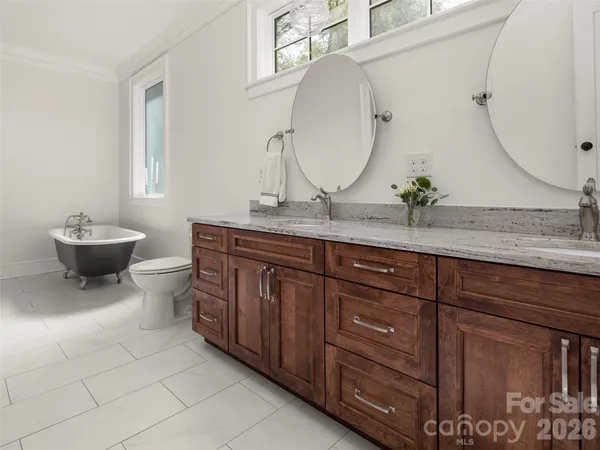 a bathroom with a granite countertop toilet sink and mirror