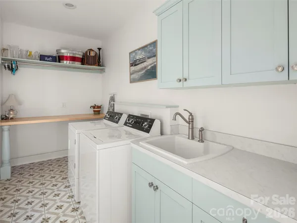 a utility room with sink dryer and washer