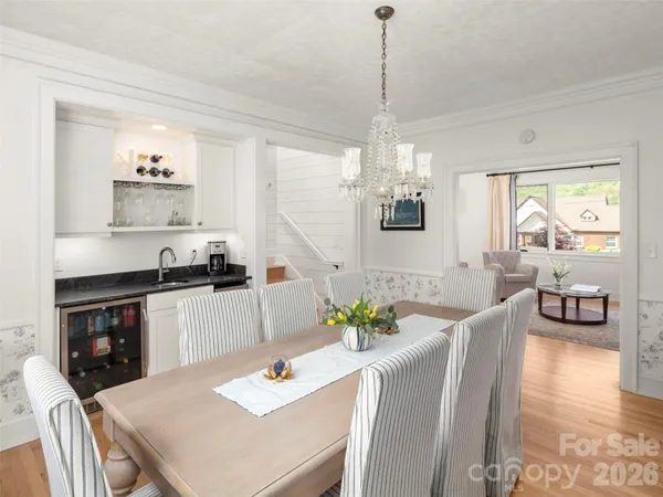 a view of a dining room with furniture a chandelier and wooden floor
