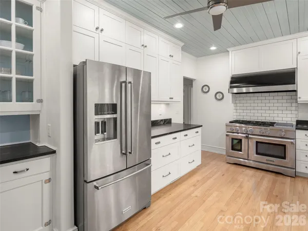 a kitchen with stainless steel appliances a refrigerator stove and cabinets