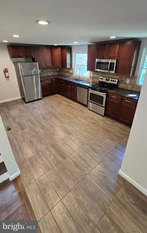 a kitchen with stainless steel appliances wooden cabinets and a counter top space