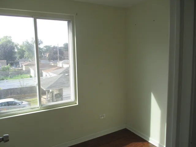a view of a small space with wooden floor and a window