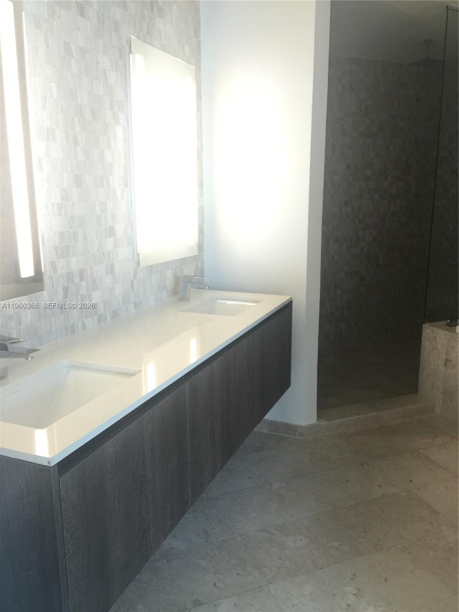 68 Southeast 6th Street, Unit 3412 Miami, FL 33131 - Photo 12 of 13 a bathroom with a sink and a bathtub