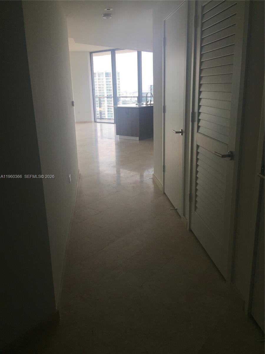 68 Southeast 6th Street, Unit 3412 Miami, FL 33131 - Photo 10 of 13 a view of a hallway with wooden floor and a cabinet