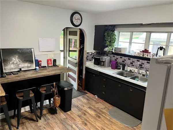 a kitchen with a table chairs a stove and a window