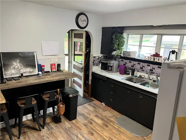 a kitchen with a table chairs a stove and a window