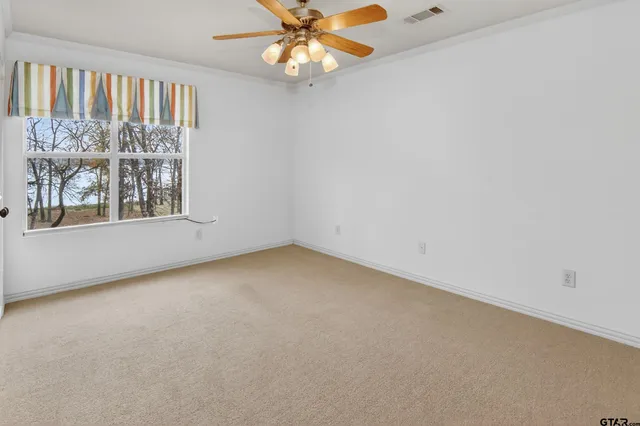 an empty room with a window and a fan
