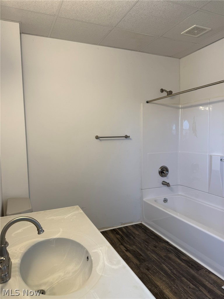 23033 Cadiz Road Freeport, OH 43973 - Photo 28 of 31 Bathroom featuring vanity, dark wood-style flooring, bathtub / shower combination, and a drop ceiling