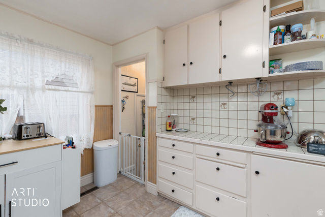 875 Patterson Street Ogden, UT 84403 - Photo 12 of 38 Kitchen featuring white cabinets, a wainscoted wall, tile countertops, and open shelves