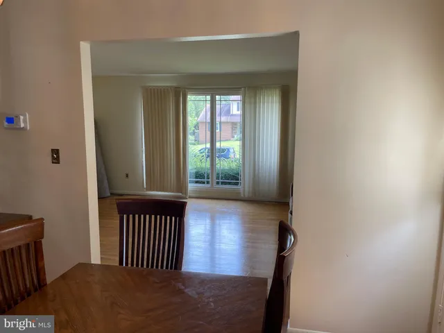 a view of a hallway with wooden floor and a bathroom
