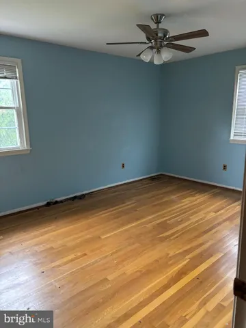 an empty room with a window and a ceiling fan