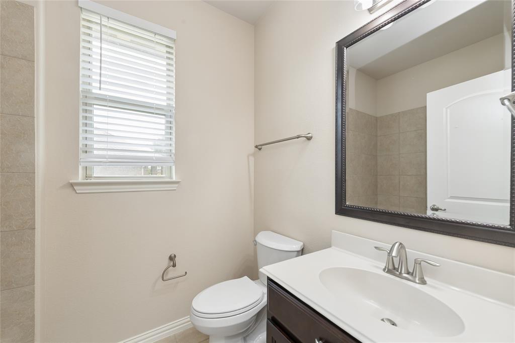 12571 Valley Spring Drive Frisco, TX 75035 - Photo 18 of 39 a bathroom with a toilet a sink a mirror and a window