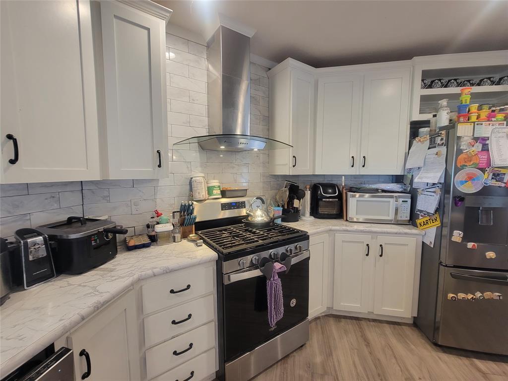 150 Hawkins Chapel Road Loving, TX 76460 - Photo 15 of 40 a kitchen with stainless steel appliances granite countertop a stove a sink and a refrigerator