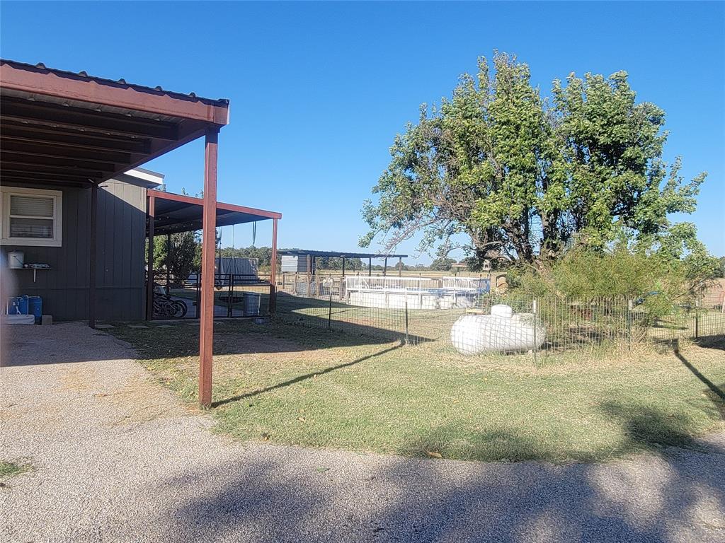 150 Hawkins Chapel Road Loving, TX 76460 - Photo 7 of 40 a view of a patio with table and chairs under an umbrella