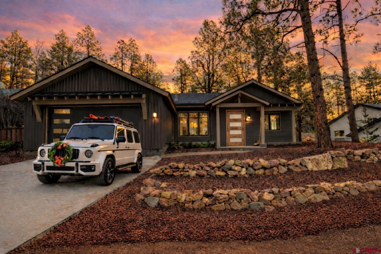 a car parked in front of a house with large trees