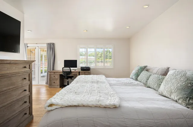 a bedroom with a large bed and a flat screen tv