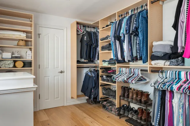 a view of walk in closet with clothes and shoes