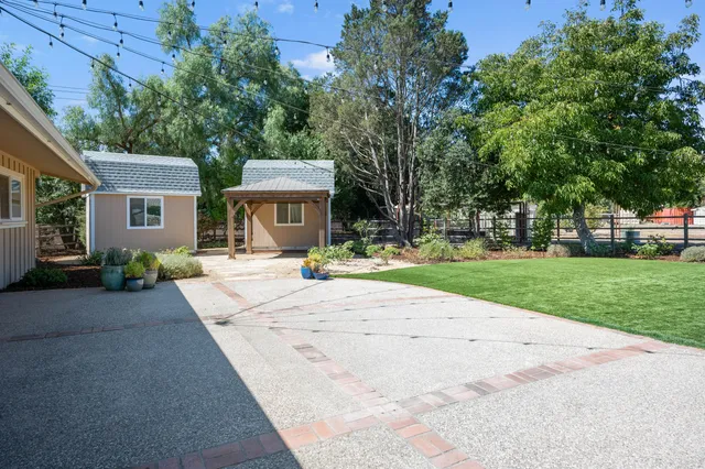a front view of a house with a yard and trees