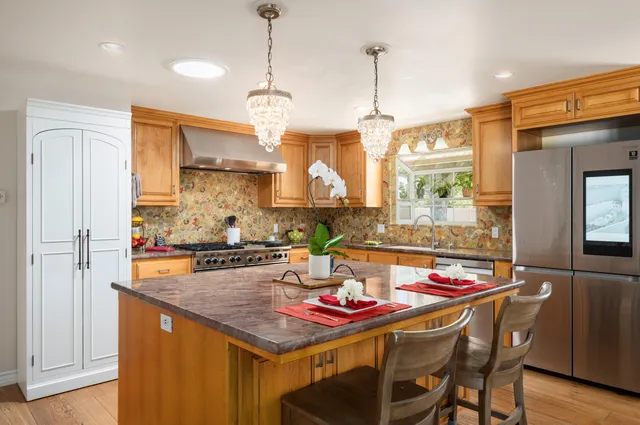 a view of a dining room and kitchen with a table chairs