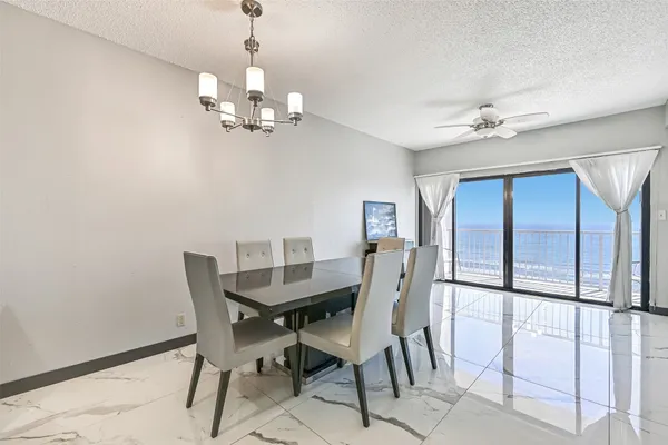a view of a dining room with furniture a chandelier and a window