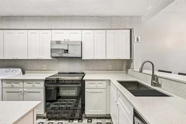 a kitchen with stainless steel appliances granite countertop a sink stove and cabinets