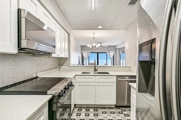 a kitchen with stainless steel appliances a sink stove and refrigerator