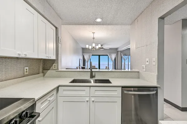 a kitchen with granite countertop a sink and white cabinets