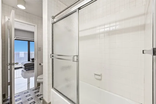 a bathroom with a shower and a glass door