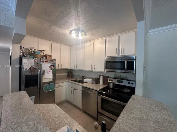 a kitchen with stainless steel appliances granite countertop a refrigerator stove and sink