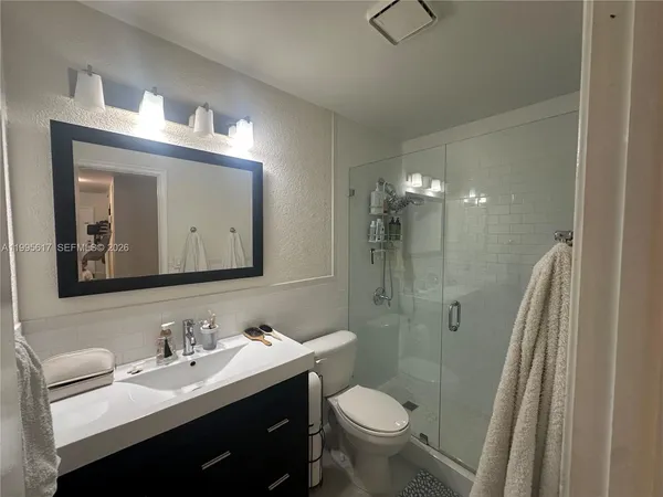 a bathroom with a double vanity sink toilet and shower