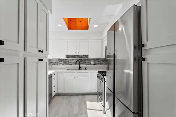 a kitchen with stainless steel appliances a refrigerator sink and cabinets