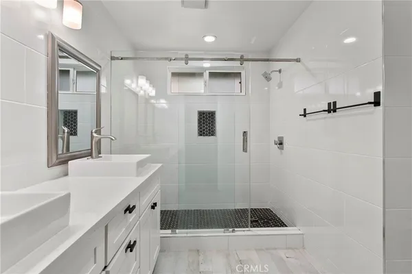 a bathroom with a tub sink shower and mirror