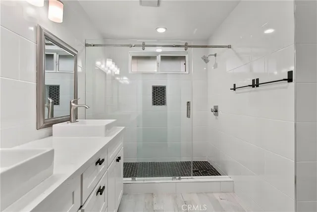 a bathroom with a tub sink shower and mirror