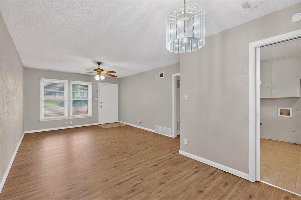 4508 Rutland Avenue Fort Worth, TX 76133 - Photo 10 of 36 an empty room with wooden floor chandelier and windows