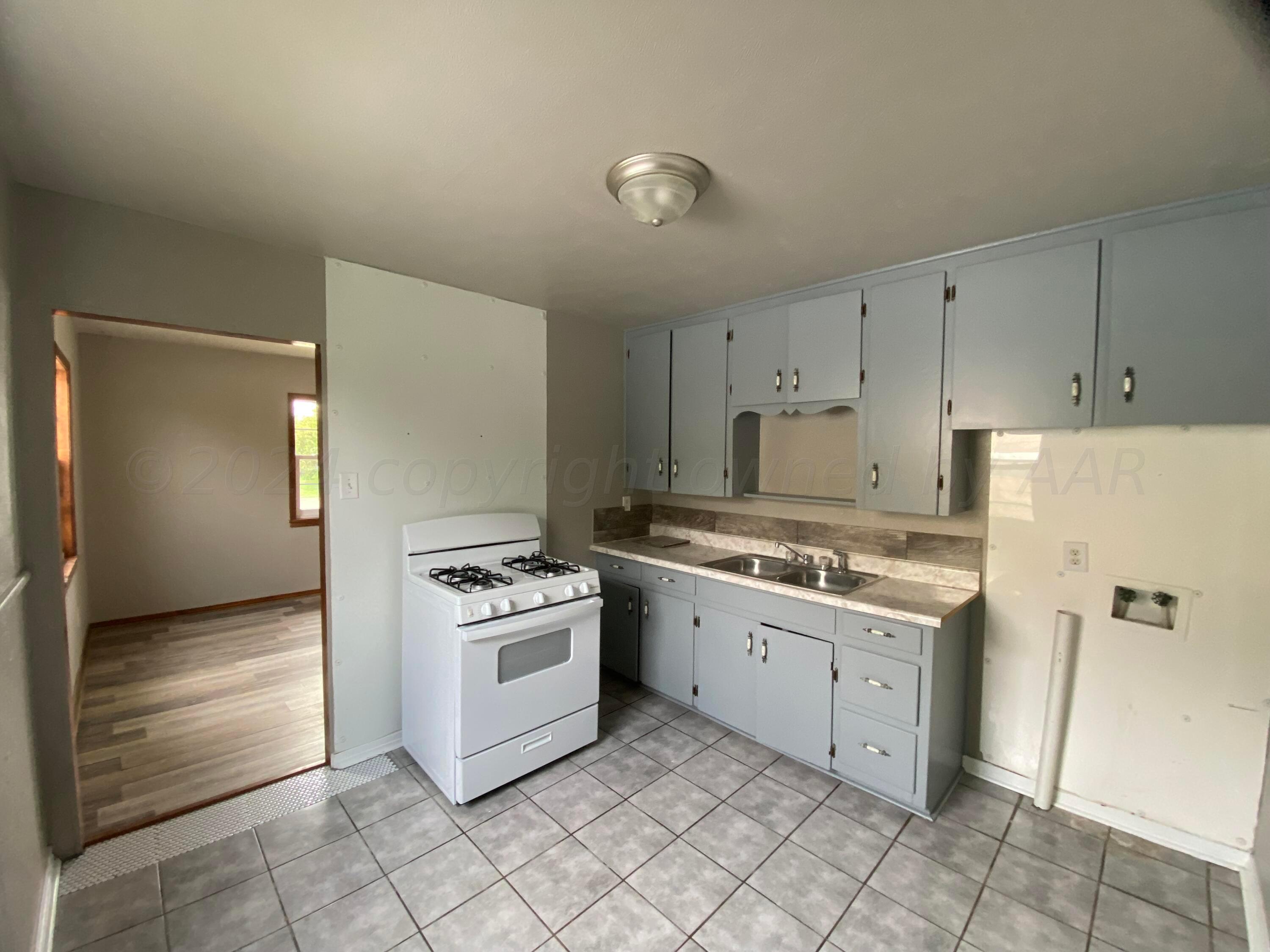 1010 Ricks Street Amarillo, TX 79104 - Photo 3 of 8 a kitchen with a stove cabinets and refrigerator