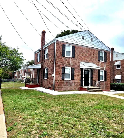 a front view of a house with a yard and trees
