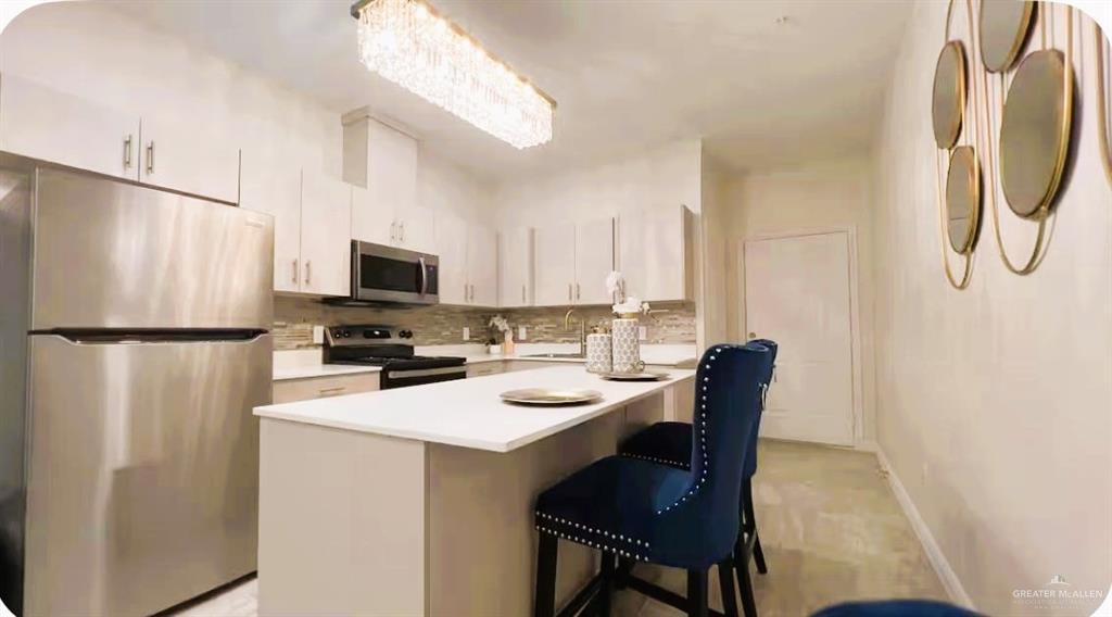 5302 Vision Street Rio Grande City, TX 78582 - Photo 7 of 19 a kitchen with a refrigerator a stove a microwave and island with wooden floor
