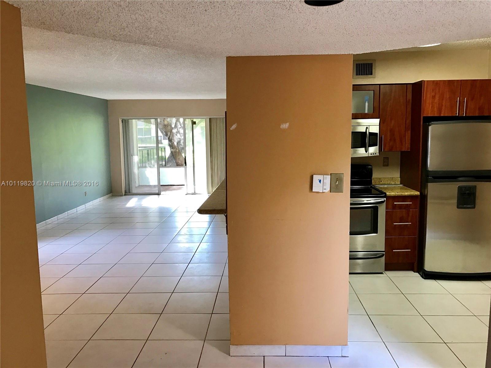 9079 Southwest 138th Place, Unit 9079 Miami, FL 33186 - Photo 3 of 34 a view of a kitchen with furniture and an empty room