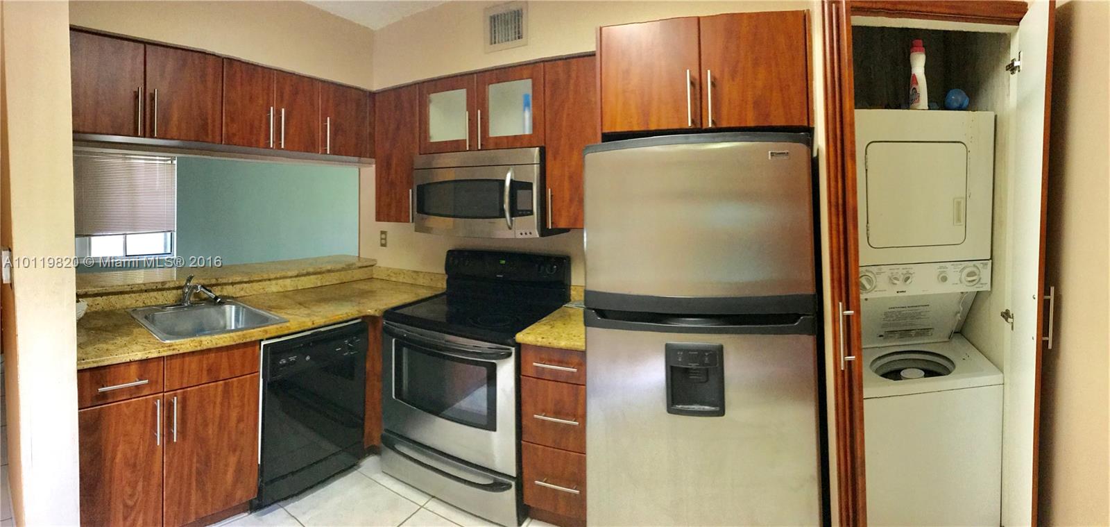 9079 Southwest 138th Place, Unit 9079 Miami, FL 33186 - Photo 10 of 34 a kitchen with stainless steel appliances granite countertop a stove a sink and a microwave