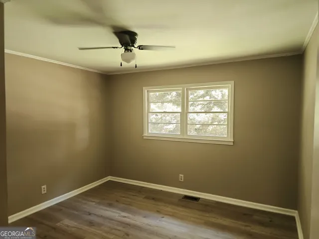 an empty room with a window and wooden floor
