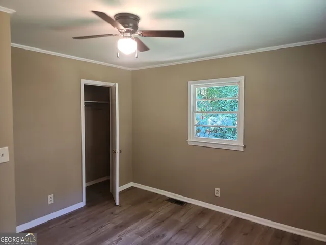 an empty room with a window and a ceiling fan
