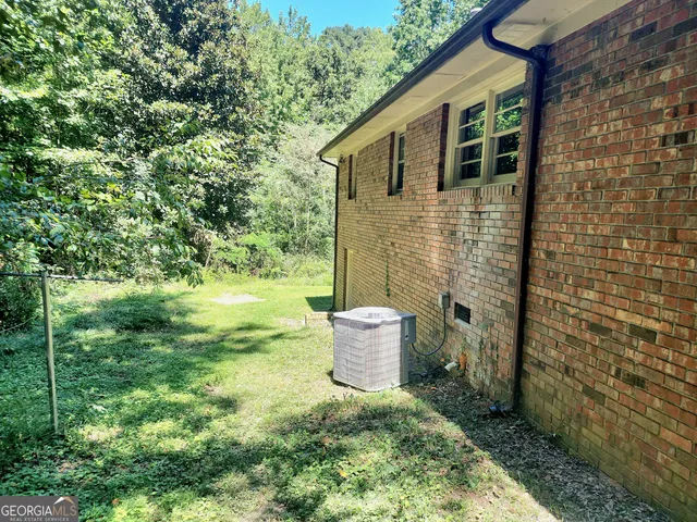 a view of a backyard with table and chairs potted plants and large tree