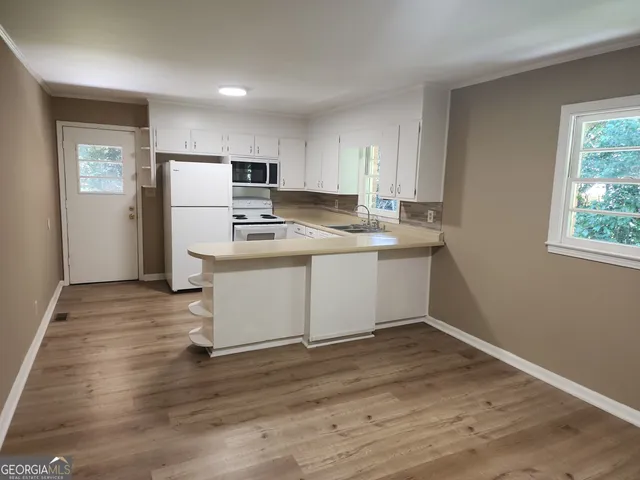 a kitchen with a sink a refrigerator and window