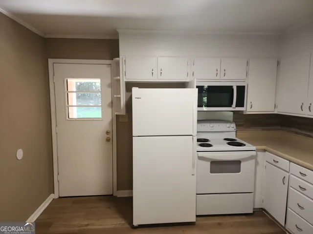 a white refrigerator freezer and a stove sitting inside of a kitchen