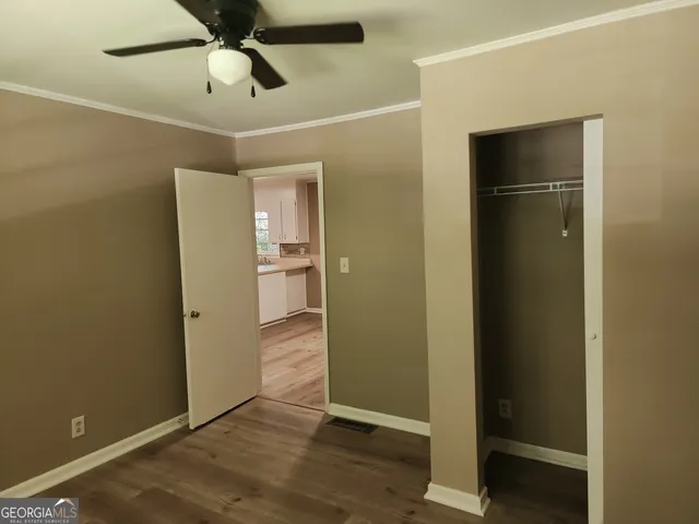an empty room with closet and wooden floor