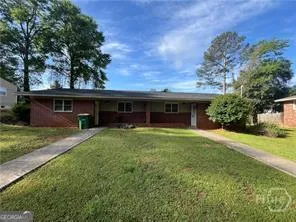a view of a house with a yard and large tree
