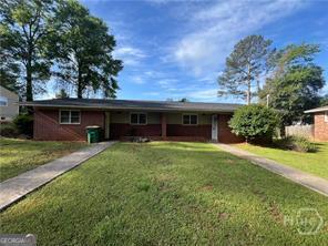 a view of a house with a yard and large tree